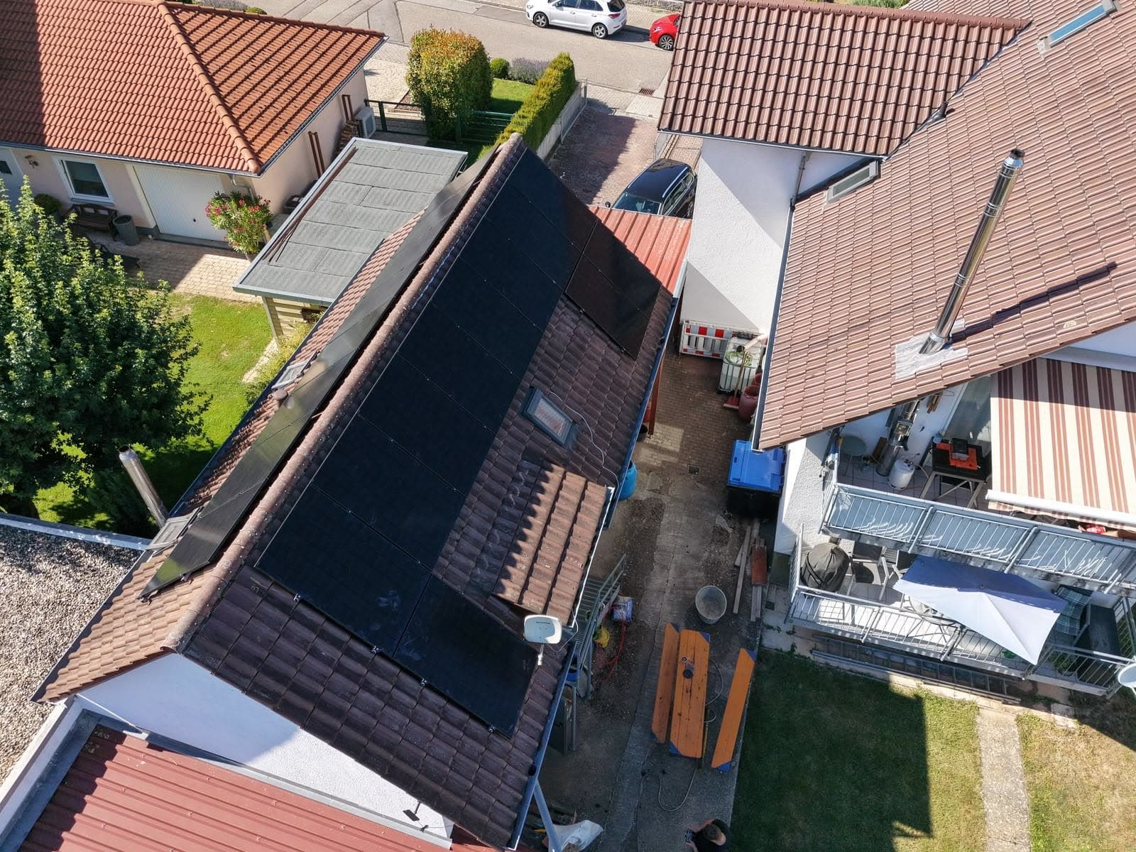 Luftaufnahme eines Einfamilienhauses, dessen Dach vollflächig mit schwarzen Solarmodulen belegt ist